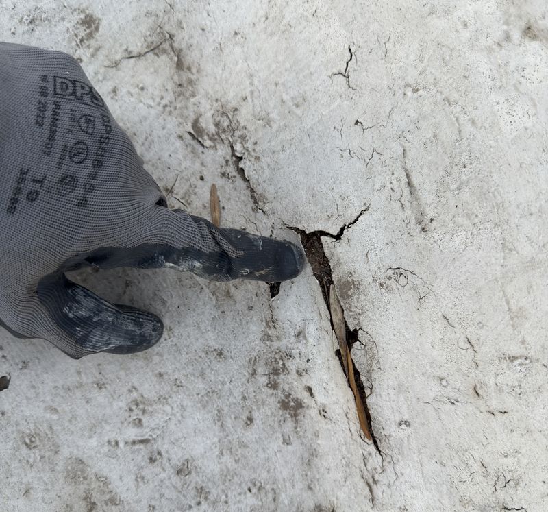 Fisura en la superficie de un techo señalada con la mano